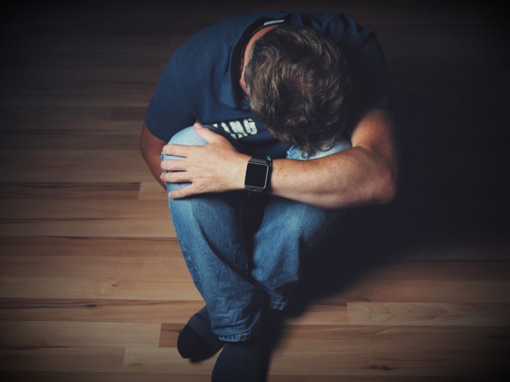 a man with bipolar disorder sitting on a floor