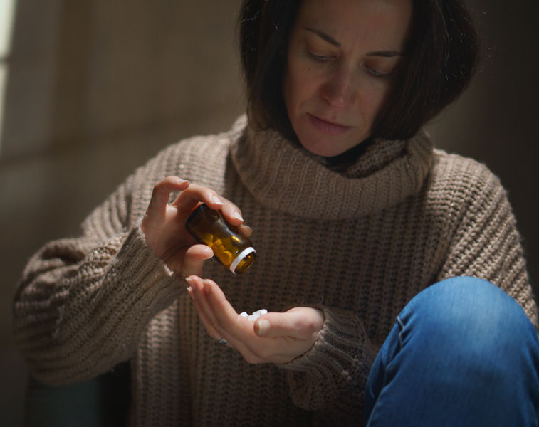 woman dumping opioid pills in her had