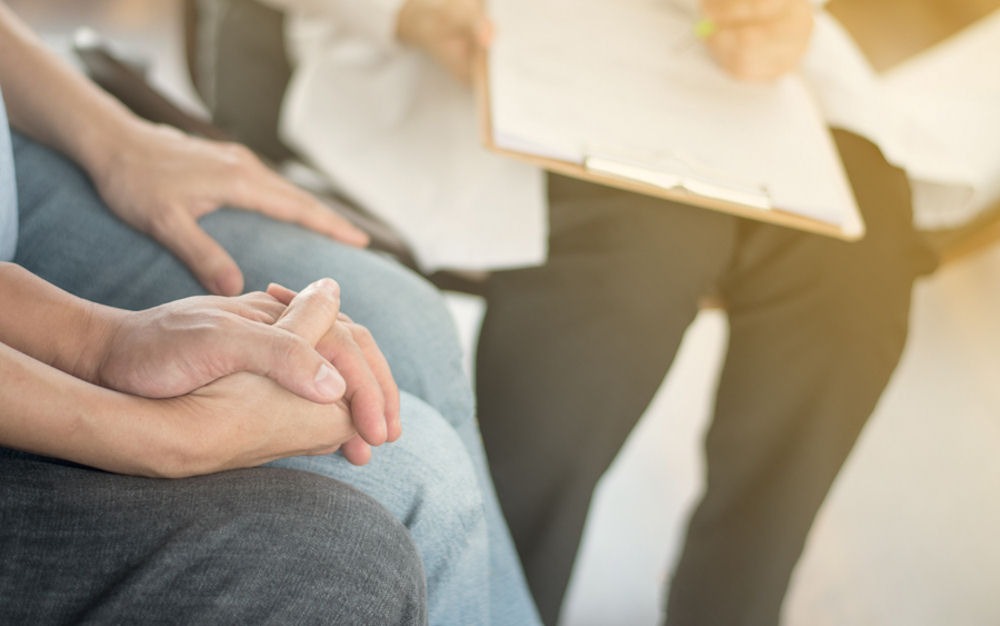 couple holding hands while doing intake for residential rehab