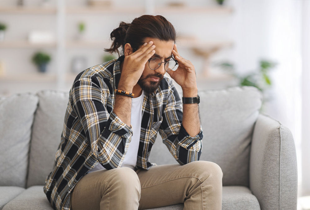 emotional man sitting on couch in therapy for mental health