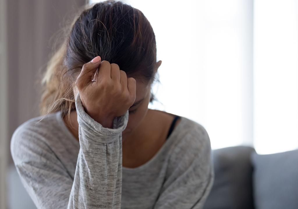 woman feeling depressed holding her head in her hand