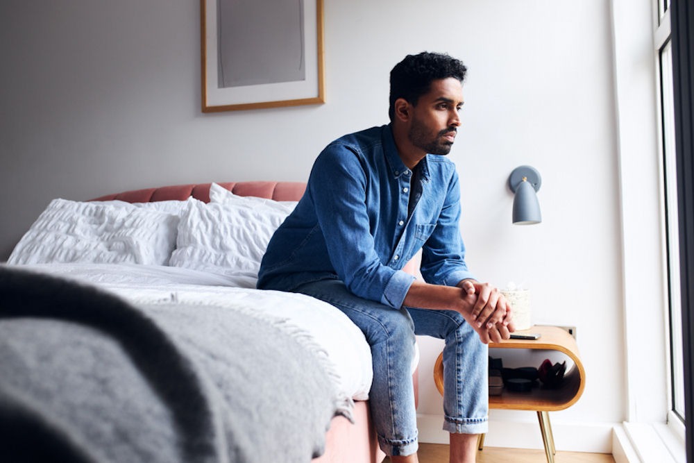 sad man sitting on his bed