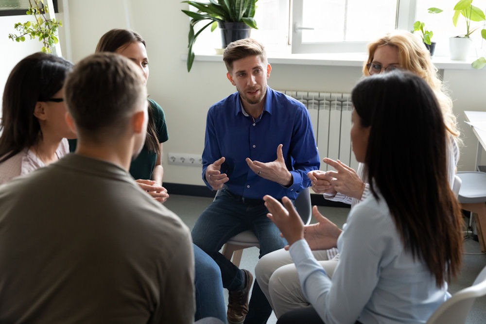 man in group thearpy responding to therapist