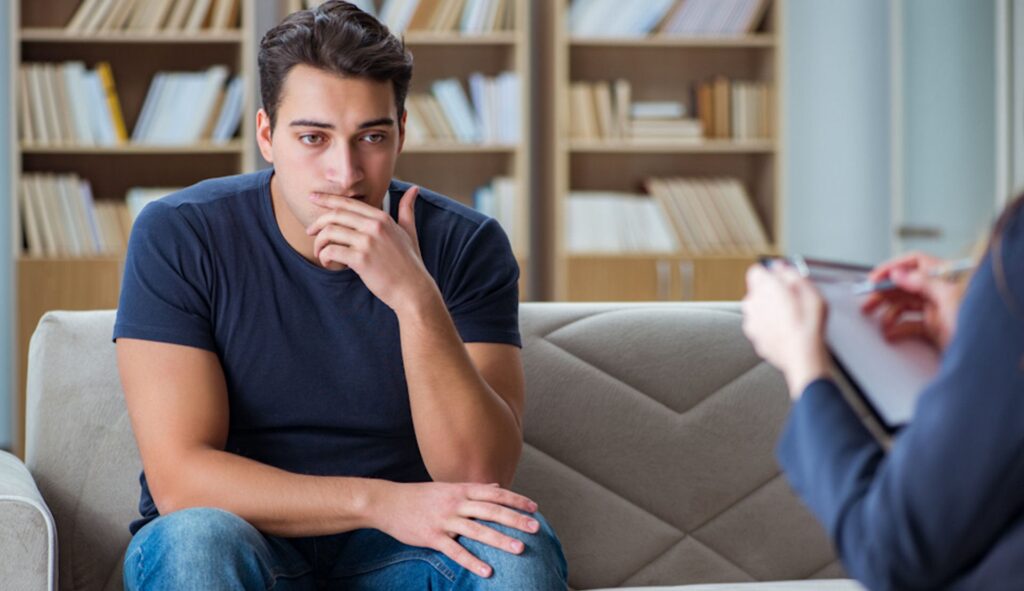 thoughtful man sitting on couch during therapy