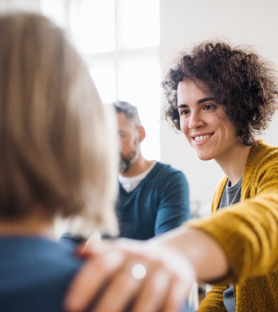 men-and-women-sitting-in-a-circle-during-group-the-2024-10-22-08-44-56-utc (2) (1) woman supporting friend at group therapy session