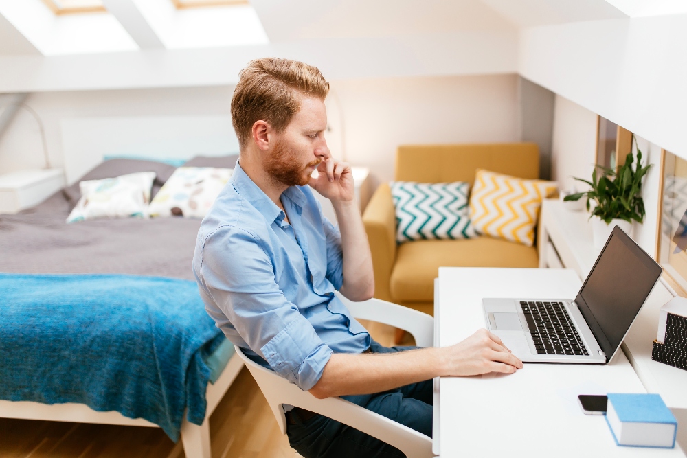 man working on computer at sober living